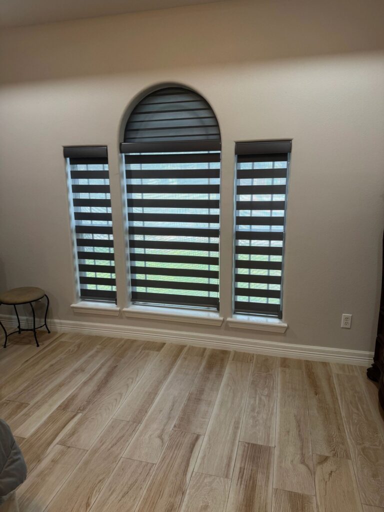 Zebra blinds covering a triple-arch window set in a living room