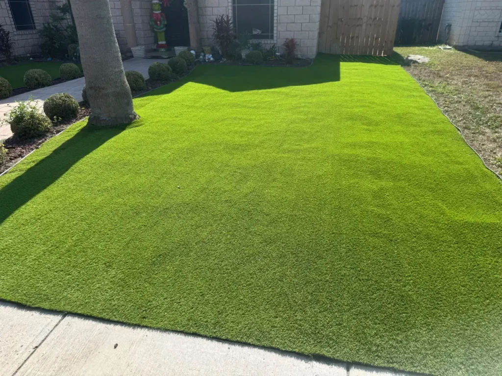 Green turf covering a front yard beside a brick home